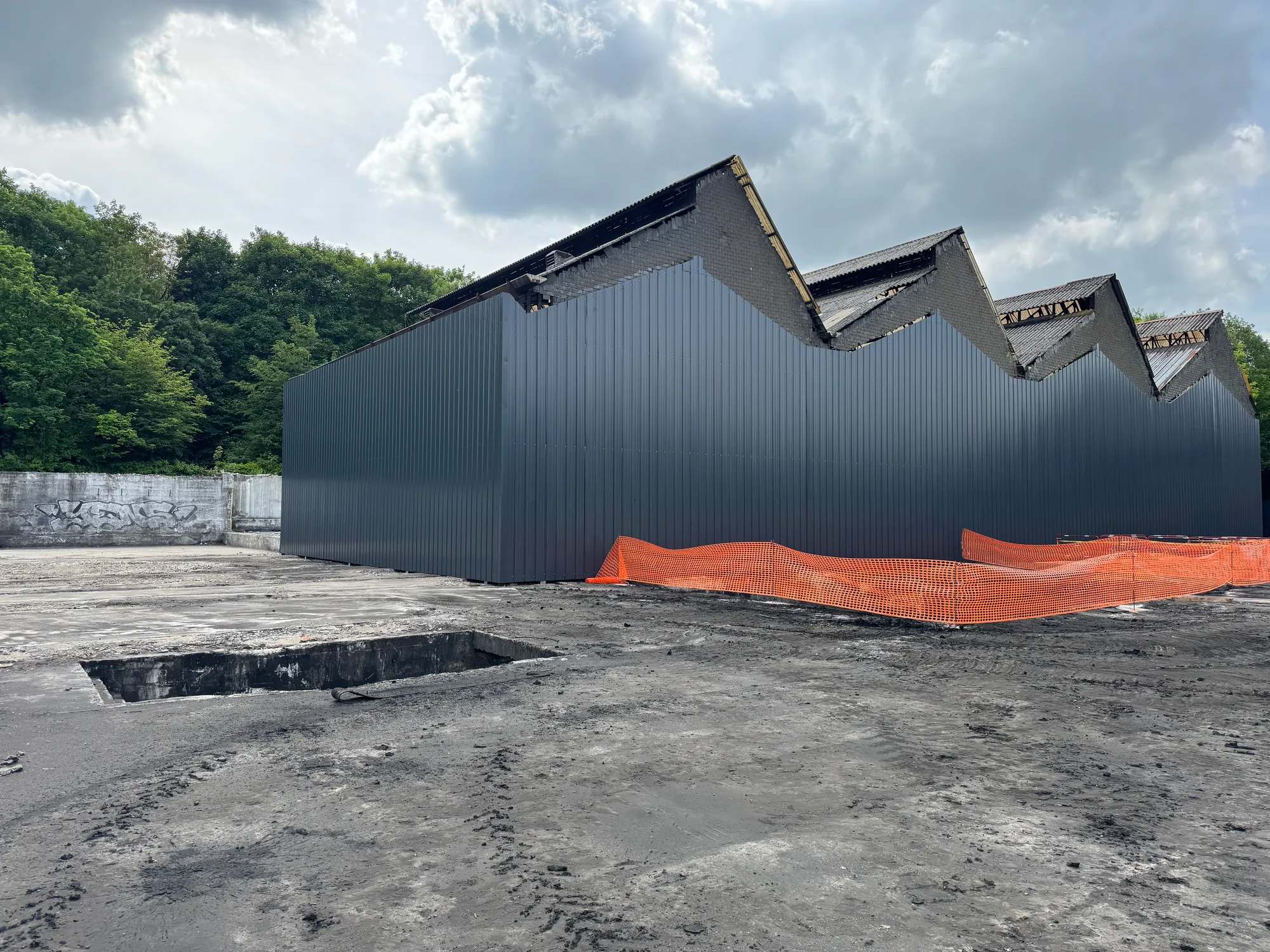Bardage acier anthracite sur un bâtiment industriel à sheds