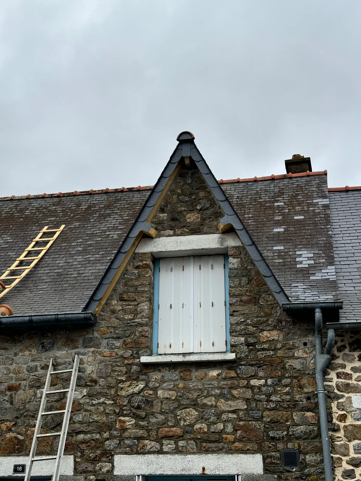 Rives et lucarne en ardoise rénovées sur une maison en pierre